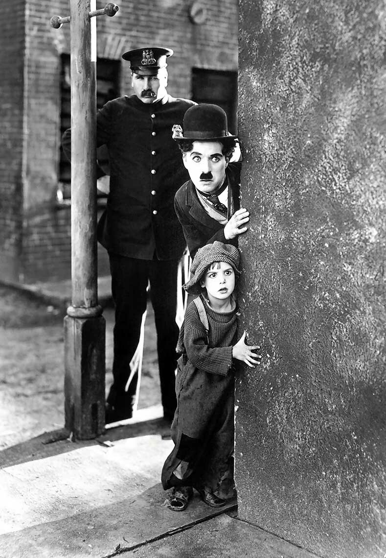 Charlie Chaplin The Kid 1921 peeking out from behind wall Photo